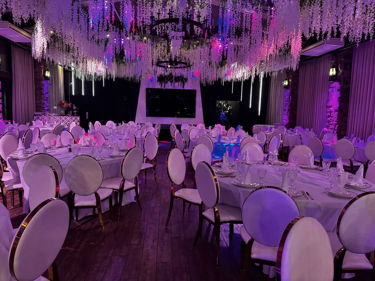 Banquet hall set for an evening celebration with floral ceiling and ambient lighting